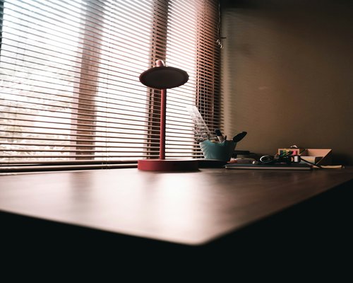 Libreta de apuntes y anteojos descansando sobre un escritorio de madera